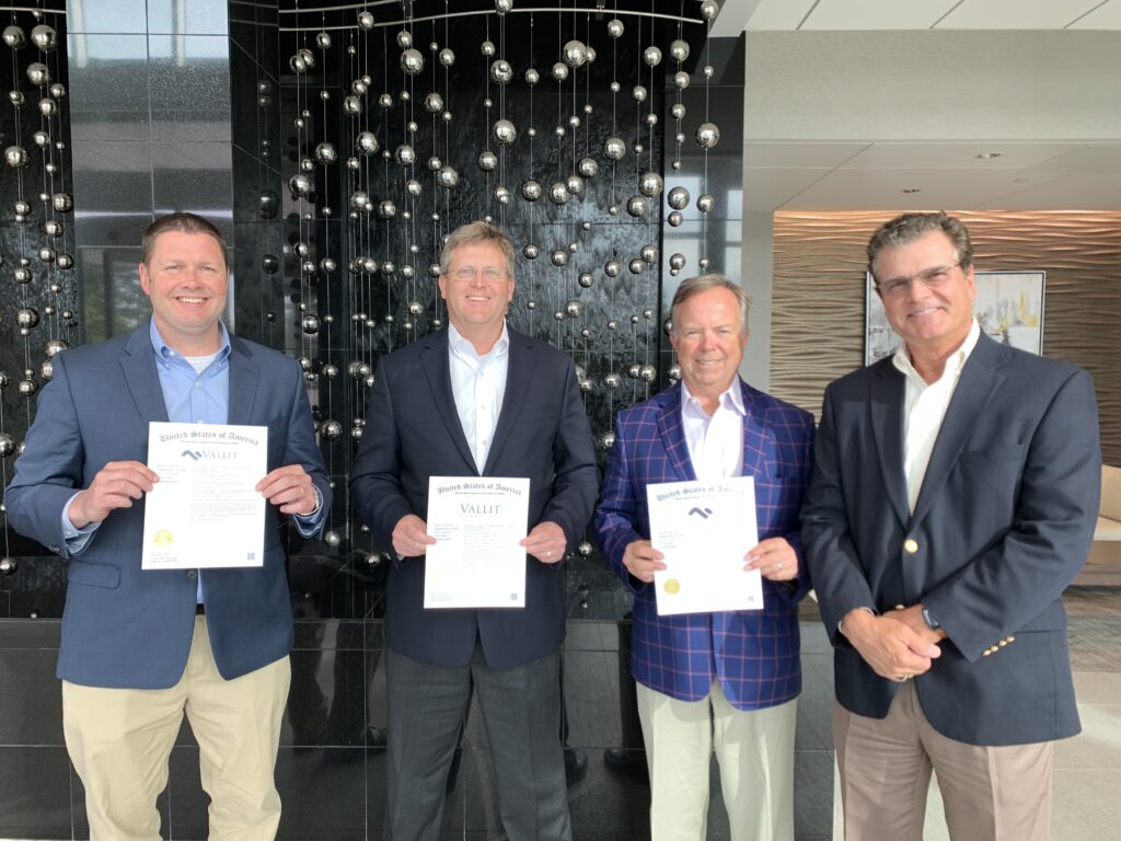 vallit advisors holding up their trademark certificates